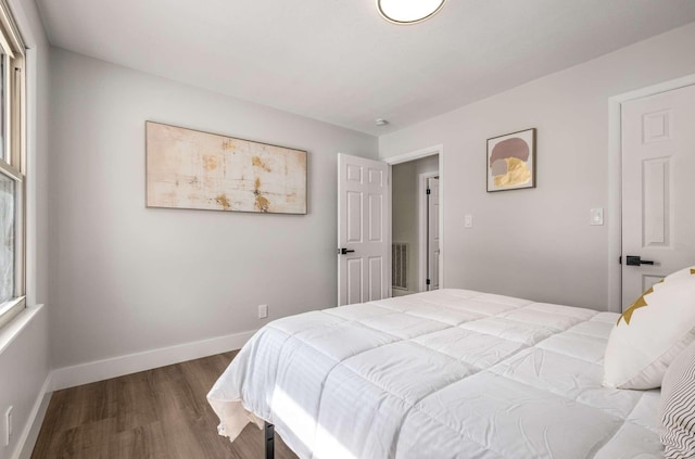 bedroom with visible vents, baseboards, and wood finished floors