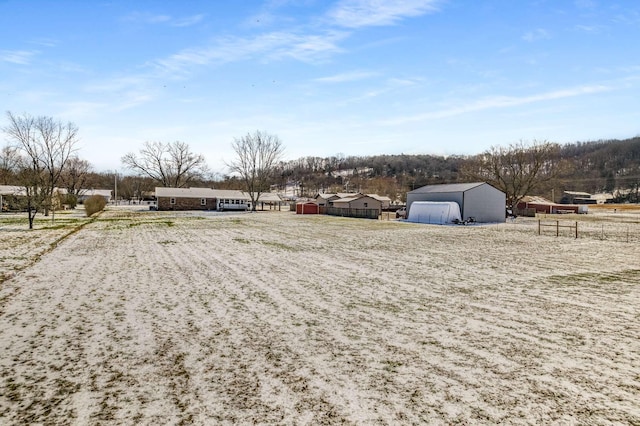 view of yard with a rural view, fence, and an outbuilding