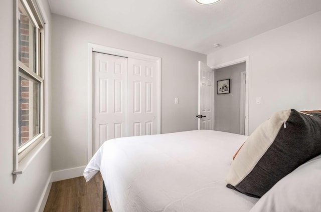 bedroom featuring a closet, wood finished floors, and baseboards