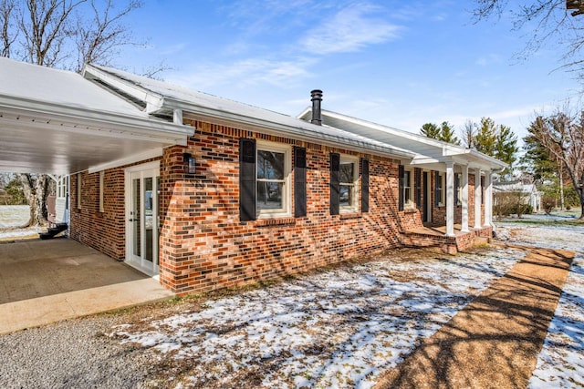 view of front of home featuring an attached carport and brick siding