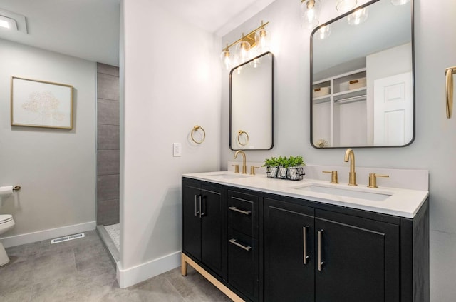 full bath featuring visible vents, a sink, baseboards, and double vanity