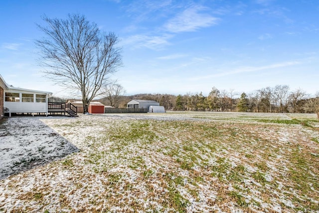 view of yard with an outbuilding, fence, and a storage shed