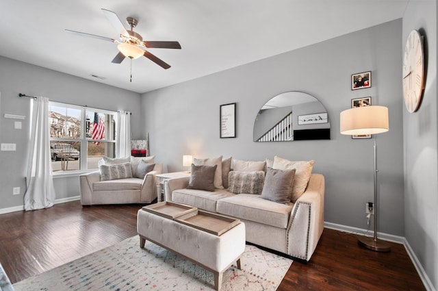 living room with arched walkways, dark wood-style flooring, and baseboards