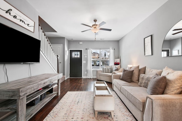 living room with stairs, wood finished floors, a ceiling fan, and baseboards