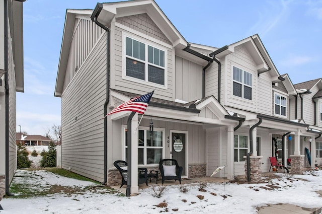 craftsman-style house featuring board and batten siding, covered porch, and stone siding