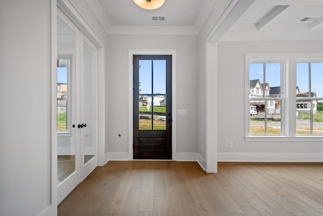 foyer entrance with a wealth of natural light, visible vents, and light wood-style flooring