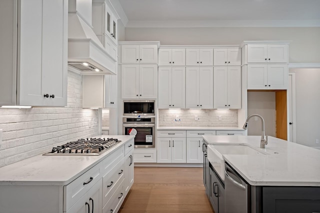 kitchen with stainless steel appliances, light stone counters, custom exhaust hood, and white cabinets