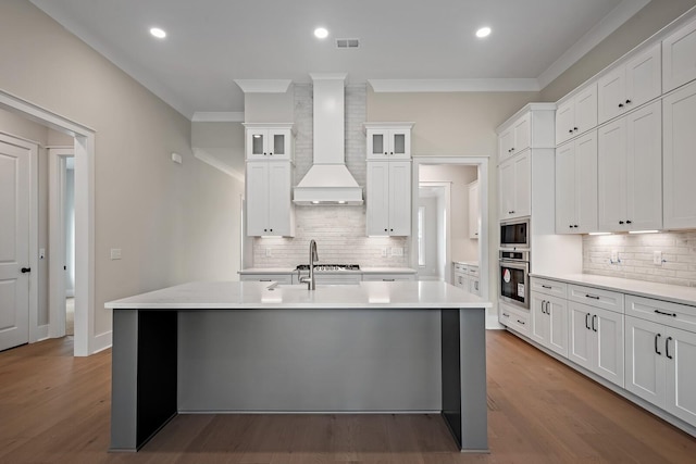 kitchen with light countertops, premium range hood, glass insert cabinets, and white cabinetry