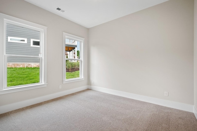 carpeted spare room featuring visible vents and baseboards