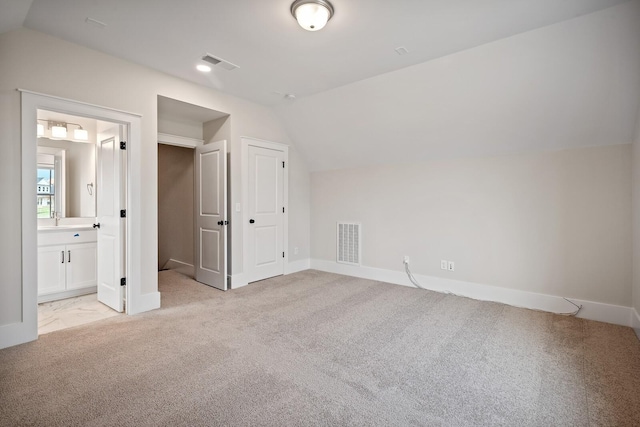 additional living space featuring visible vents, vaulted ceiling, light carpet, and baseboards