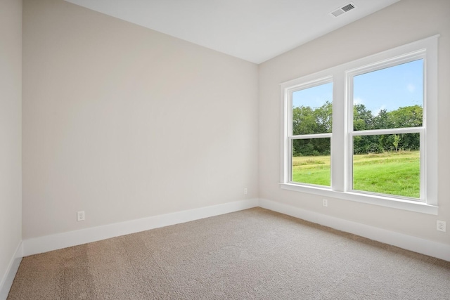 unfurnished room featuring carpet, visible vents, and baseboards