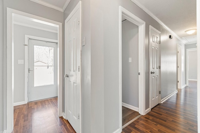 hall featuring baseboards, ornamental molding, and dark wood finished floors