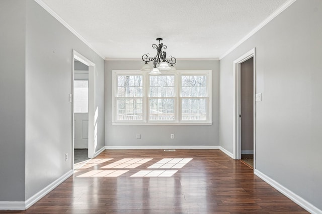 unfurnished dining area featuring an inviting chandelier, ornamental molding, and wood finished floors