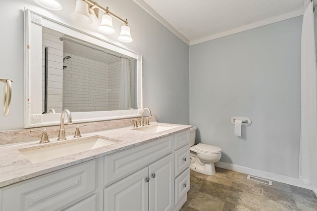 bathroom featuring visible vents, a tile shower, a sink, and ornamental molding