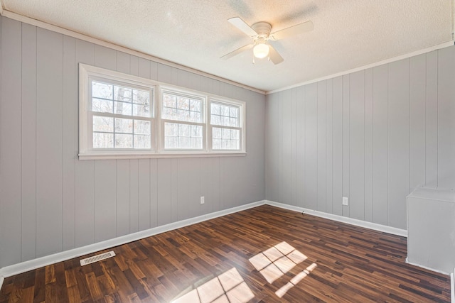 unfurnished room with ceiling fan, a textured ceiling, visible vents, baseboards, and dark wood-style floors