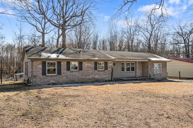 ranch-style home featuring a front lawn and brick siding