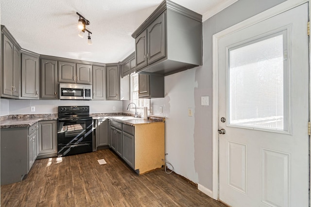 kitchen with black range with electric cooktop, stainless steel microwave, and gray cabinetry