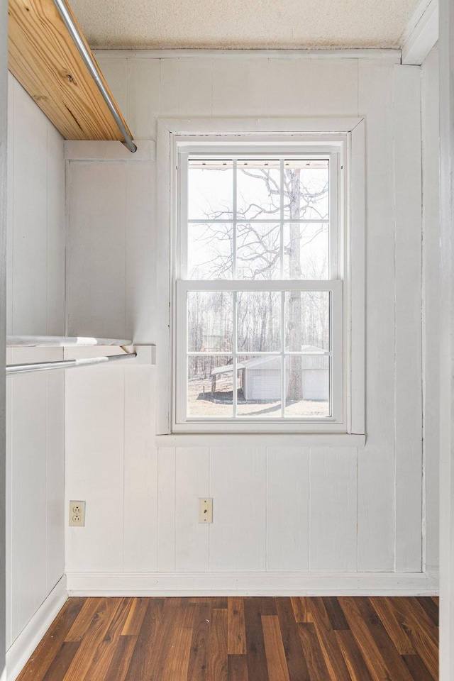 unfurnished room featuring dark wood-style floors, plenty of natural light, and a textured ceiling