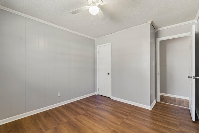 unfurnished room featuring dark wood-style floors, ornamental molding, and a textured ceiling