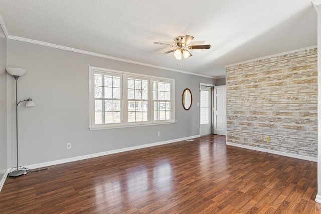 empty room with baseboards, dark wood finished floors, ceiling fan, ornamental molding, and a textured ceiling