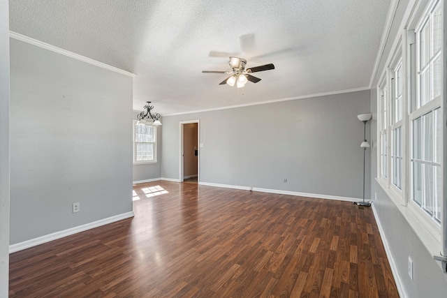 empty room featuring a textured ceiling, ornamental molding, and dark wood-type flooring