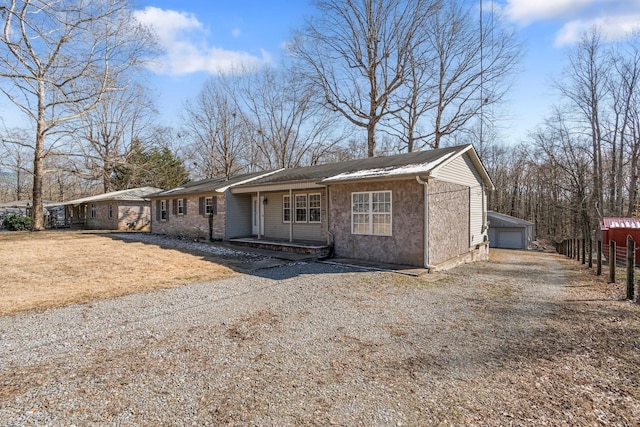 view of front facade with a garage, a porch, and an outbuilding