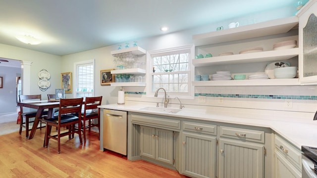 kitchen featuring a sink, open shelves, light countertops, and dishwasher