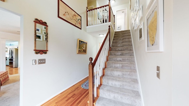 staircase with baseboards and wood finished floors