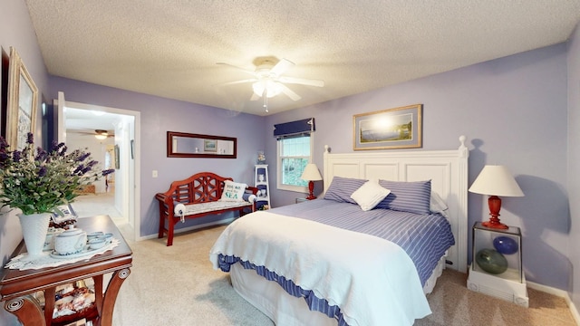 bedroom with ceiling fan, baseboards, a textured ceiling, and light colored carpet