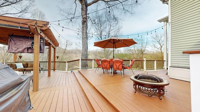 wooden terrace featuring a fire pit and outdoor dining space