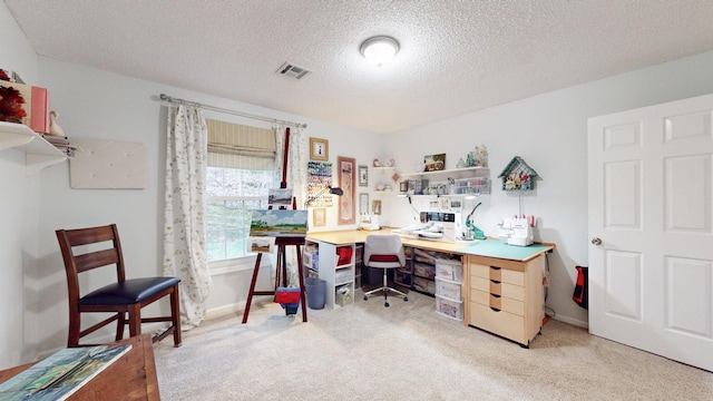 office area with light carpet, a textured ceiling, visible vents, and baseboards