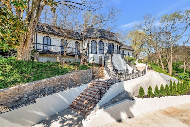 view of front of home with stairway and stucco siding