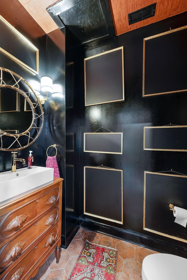 half bathroom featuring toilet, visible vents, and vanity