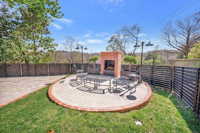 view of patio / terrace with an outdoor brick fireplace and fence