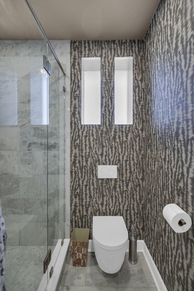 full bathroom with a stall shower, marble finish floor, baseboards, and toilet