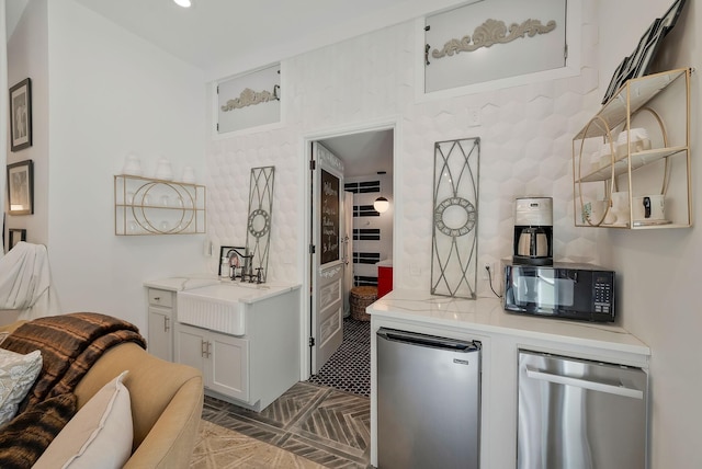 kitchen with appliances with stainless steel finishes, light countertops, and a sink