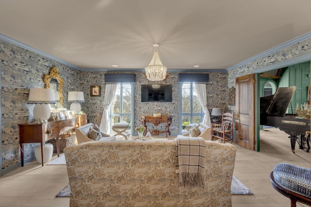 living area featuring a notable chandelier, ornamental molding, light wood-type flooring, and wallpapered walls