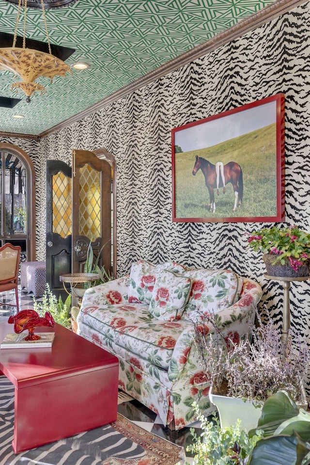 living room featuring ornamental molding, an ornate ceiling, and wallpapered walls