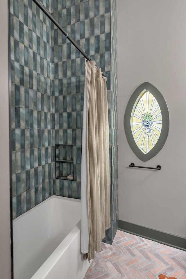 full bathroom featuring brick floor, baseboards, and shower / tub combo with curtain