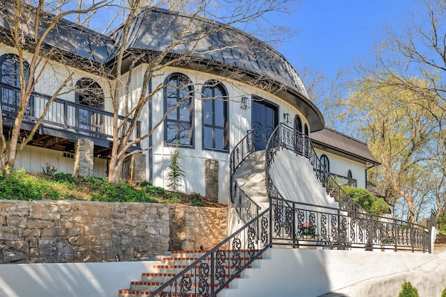 exterior space featuring metal roof and stairs