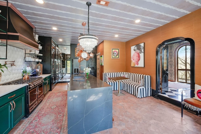 kitchen with light countertops, visible vents, a sink, double oven range, and exhaust hood