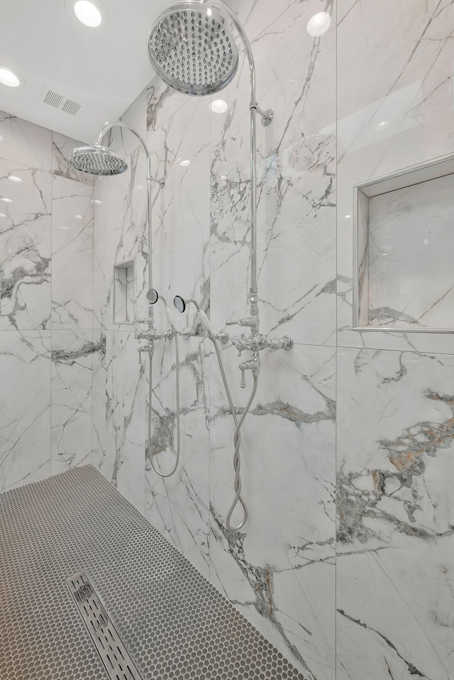 room details with recessed lighting, visible vents, and a marble finish shower