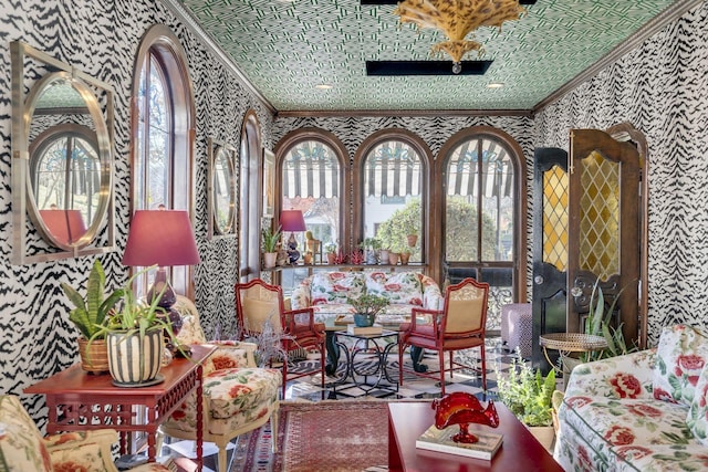 interior space featuring ornamental molding, a healthy amount of sunlight, and wallpapered walls