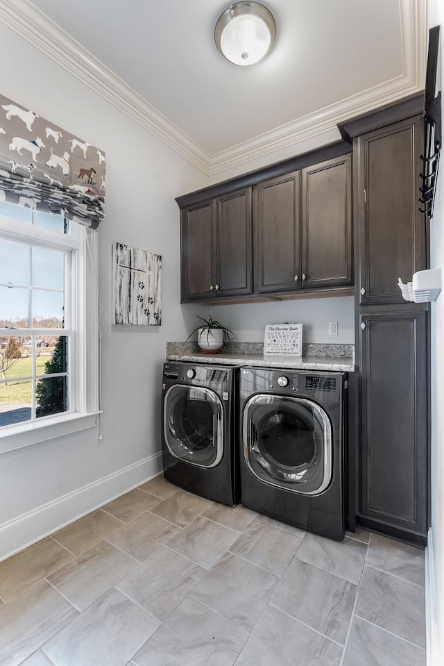 clothes washing area with cabinet space, baseboards, ornamental molding, and washer and clothes dryer