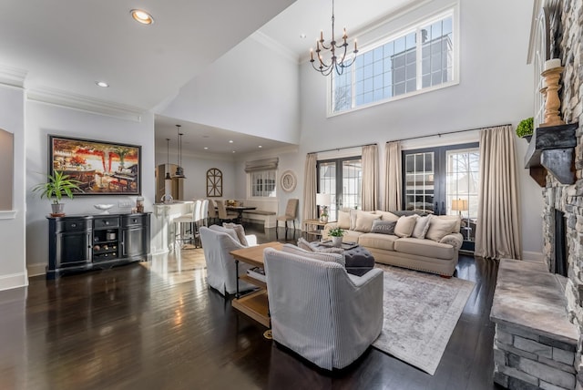 living room with dark wood-style floors, a fireplace, ornamental molding, and french doors