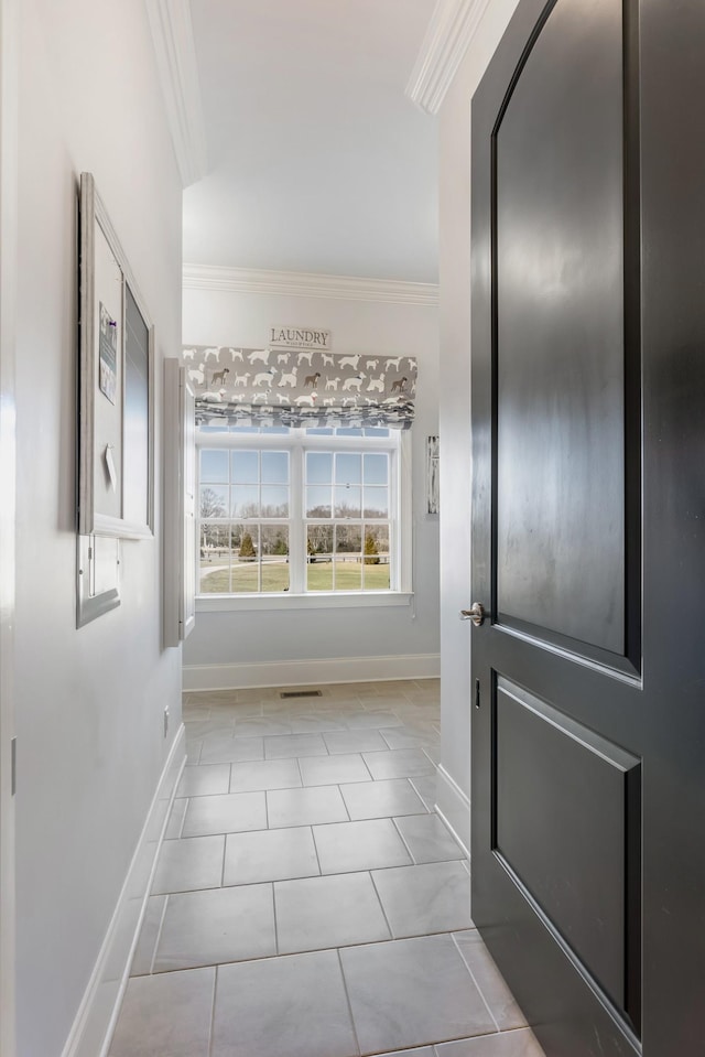 interior space featuring light tile patterned floors, ornamental molding, visible vents, and baseboards