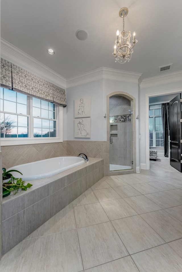 bathroom featuring a garden tub, visible vents, ornamental molding, a stall shower, and a chandelier