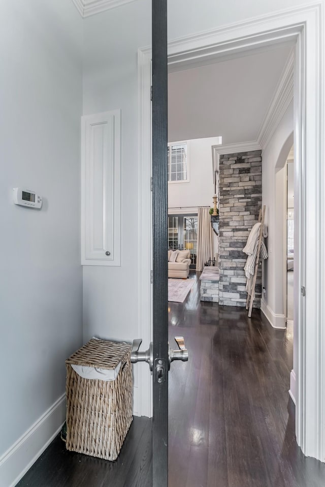 corridor featuring dark wood-style floors, baseboards, and crown molding