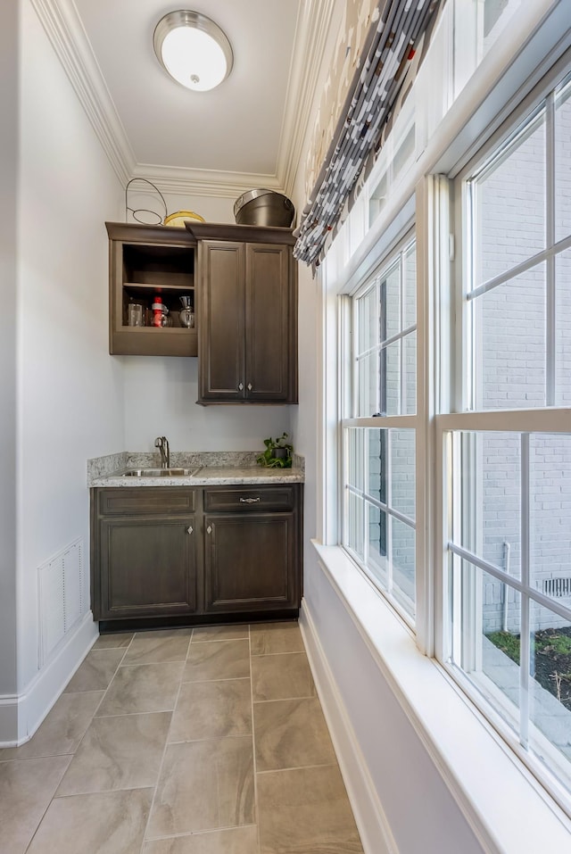 bar with plenty of natural light, crown molding, and a sink