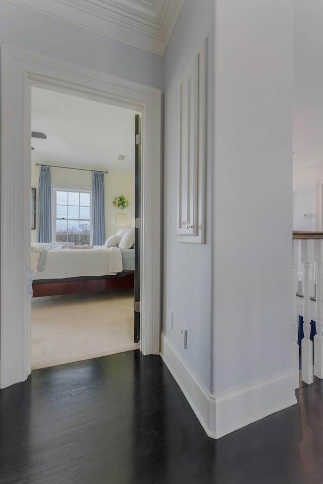 hall with baseboards, visible vents, ornamental molding, and dark wood-type flooring